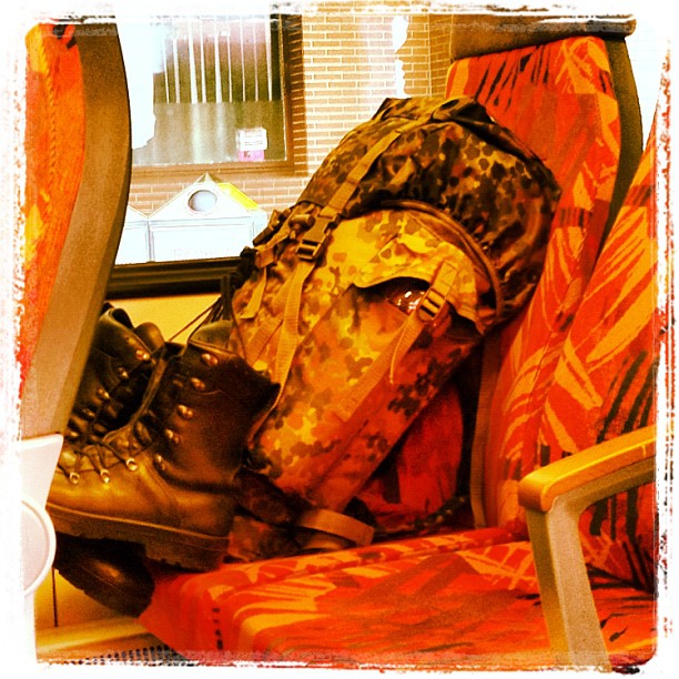A backpack of the miliary with boots on a chair in a traing